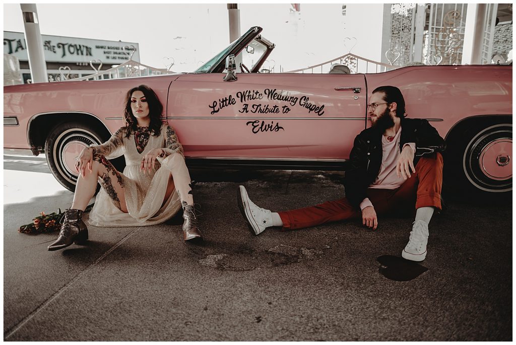 couple sitting in front of pink car