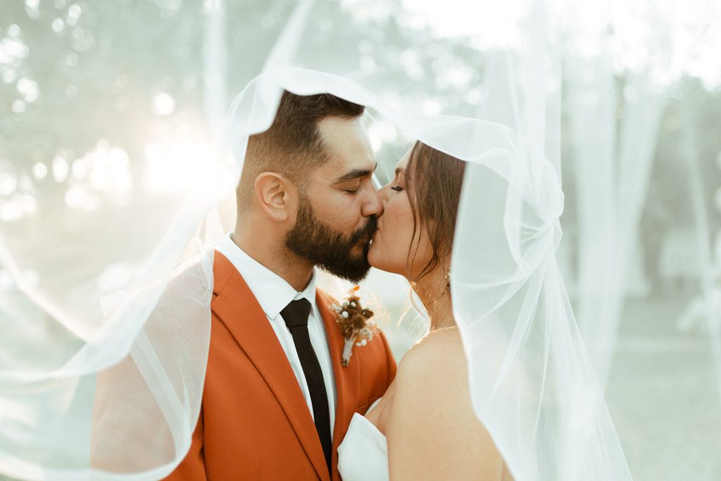 Couple kissing under veil