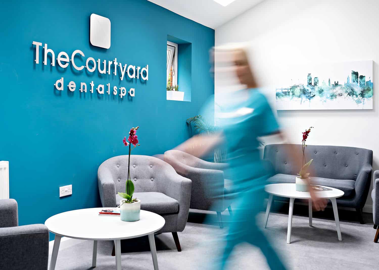 A medical professional walks hurridly through her office, which is painted blue