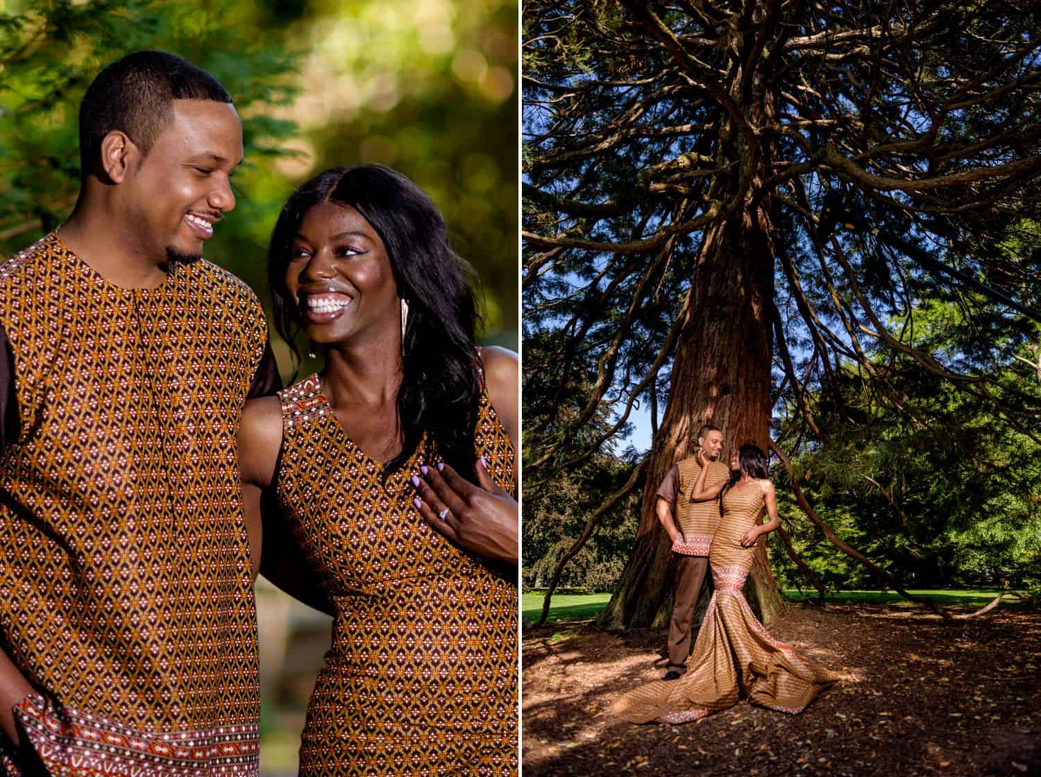 A Black couple poses in traditional African attire in front of a massive tree