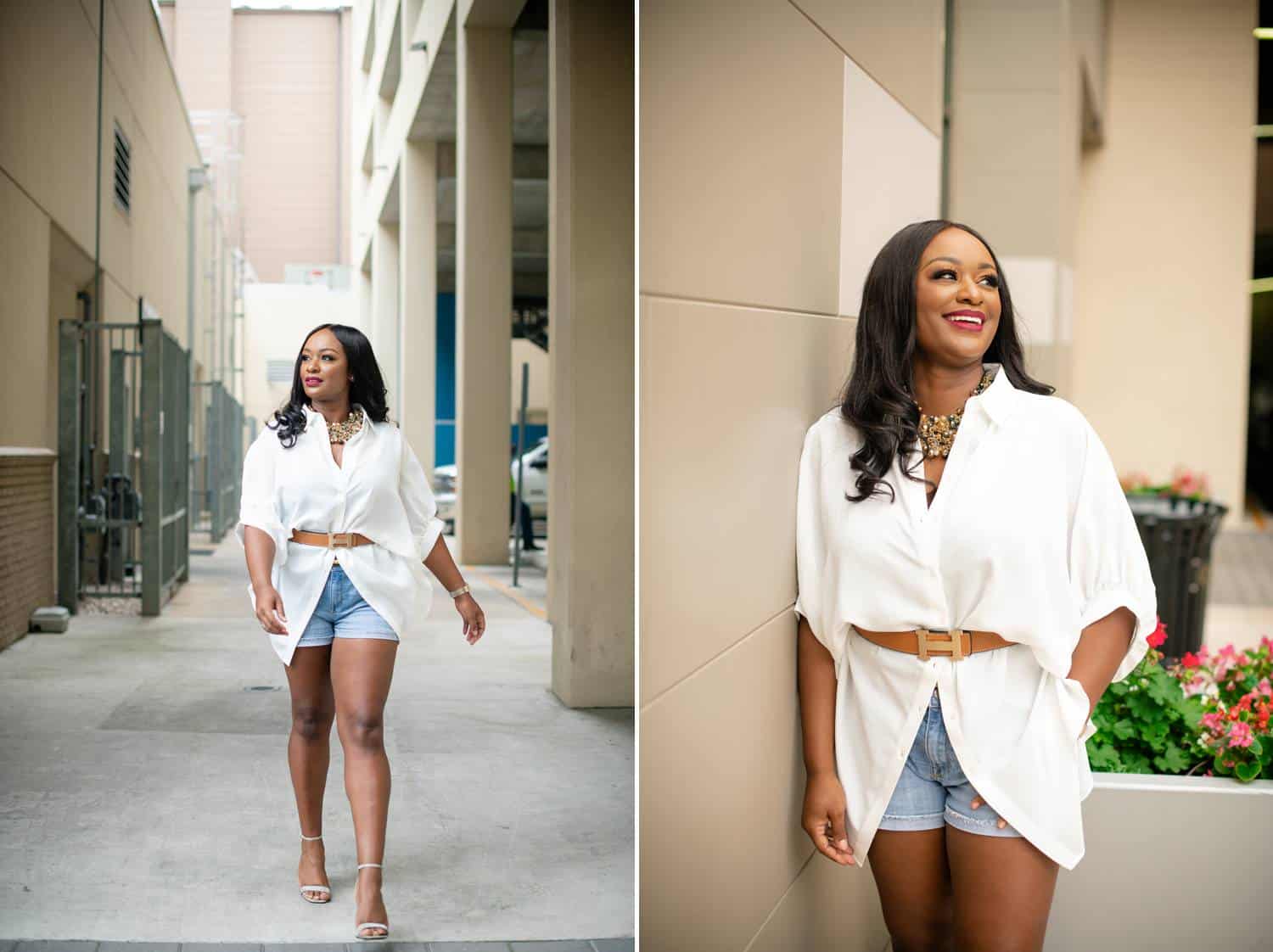 A Black woman in denim shorts and a leather-belted white top strolls through a neutral colored alleyway.