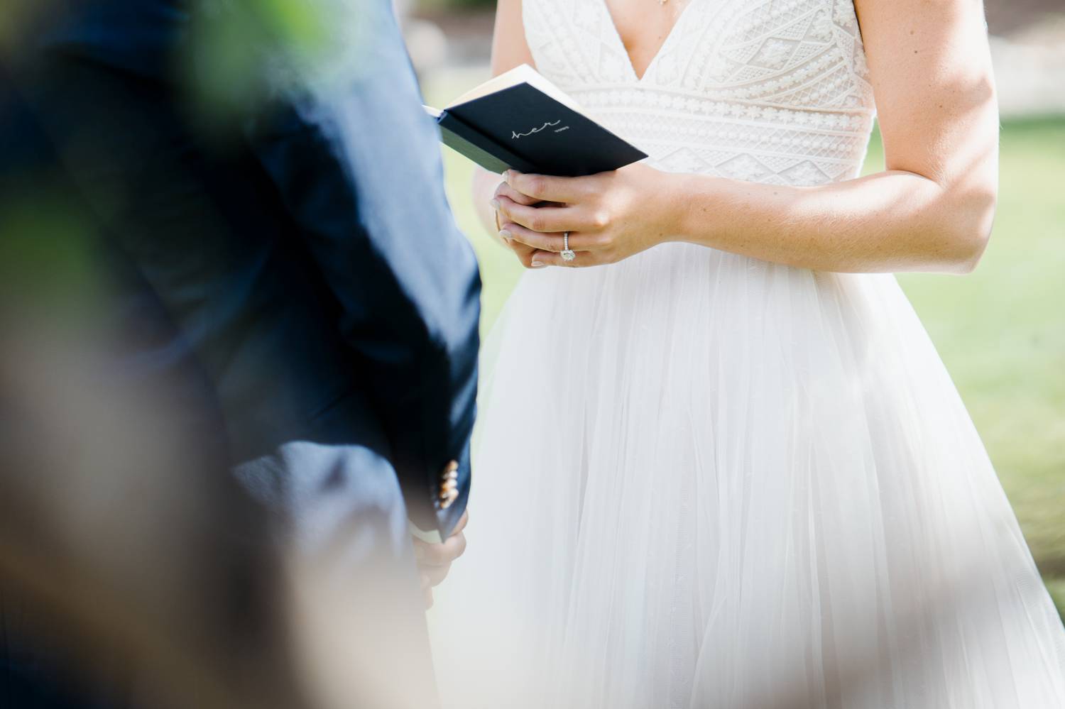 Customer Loyalty: By Nick Sparks, a mid-ceremony detail shot depicts a bride's hands holding her book of vows.