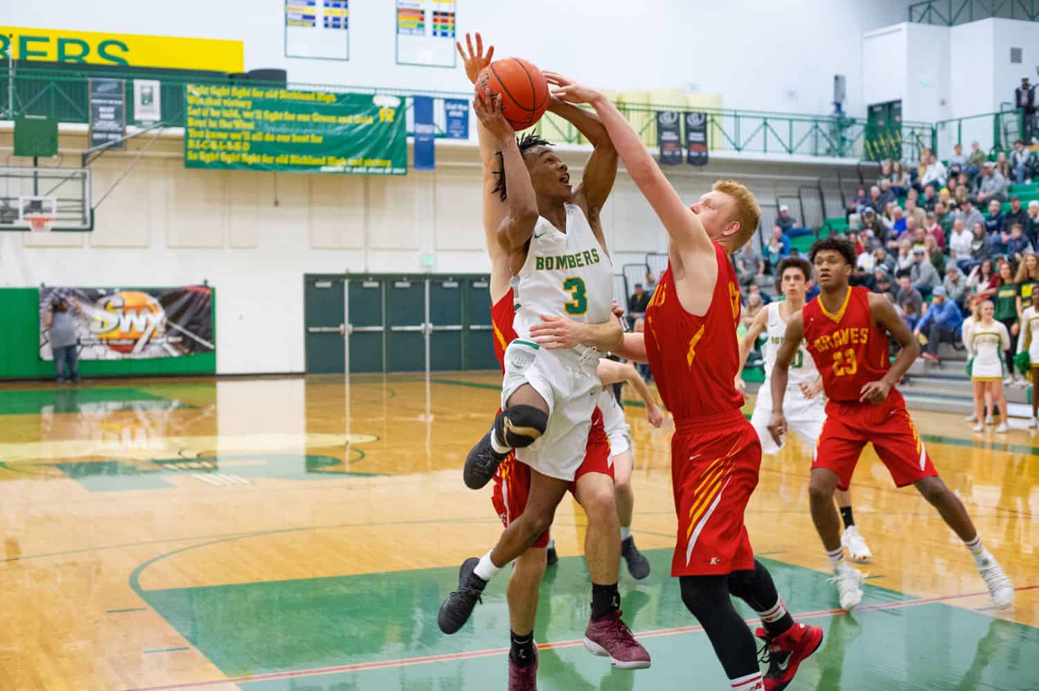 High school boys battle for control of the basketball during a game