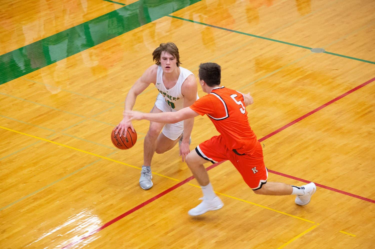 Two high school backetball players face off on the court