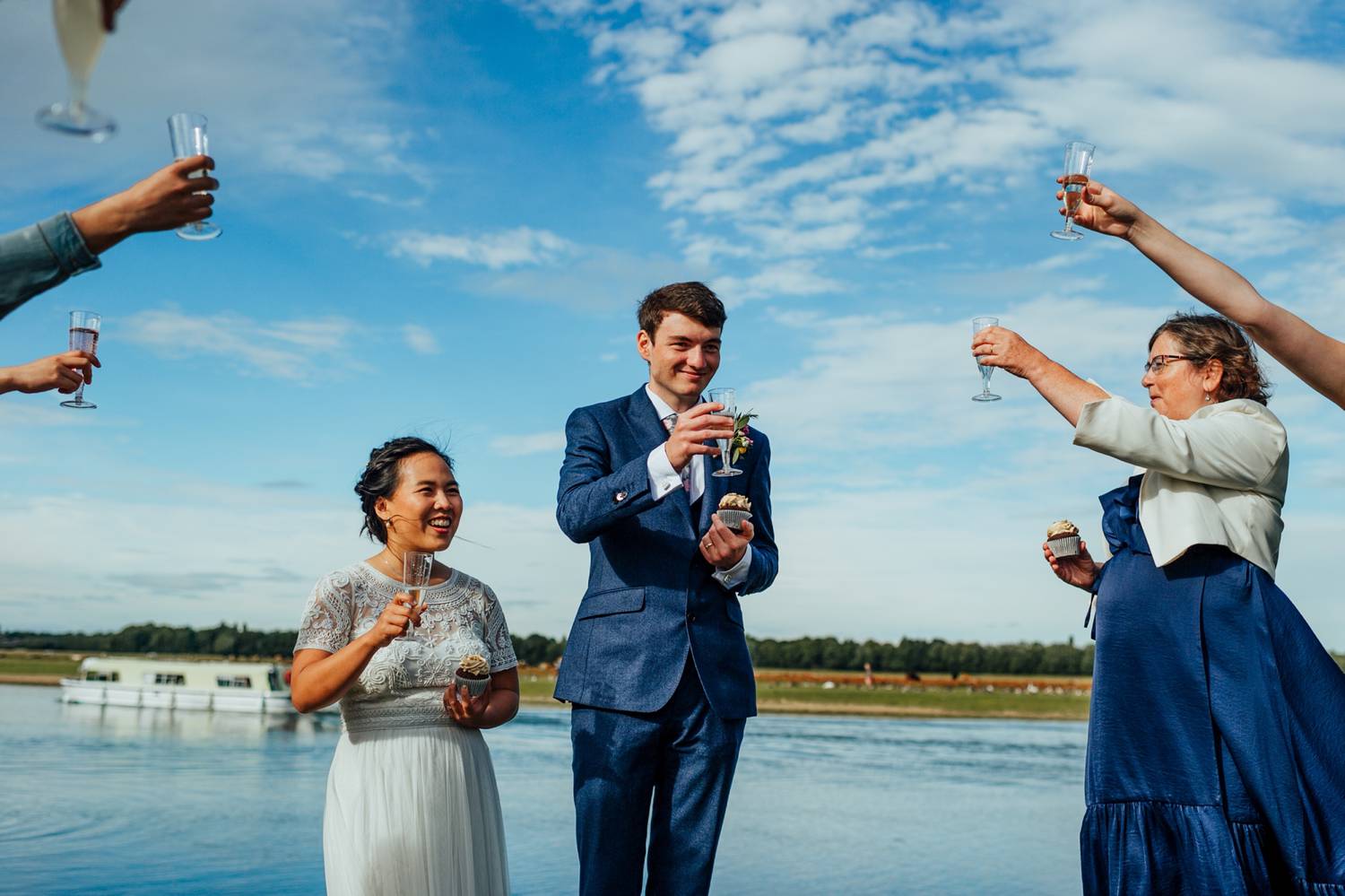 bride and groom toast by the beach