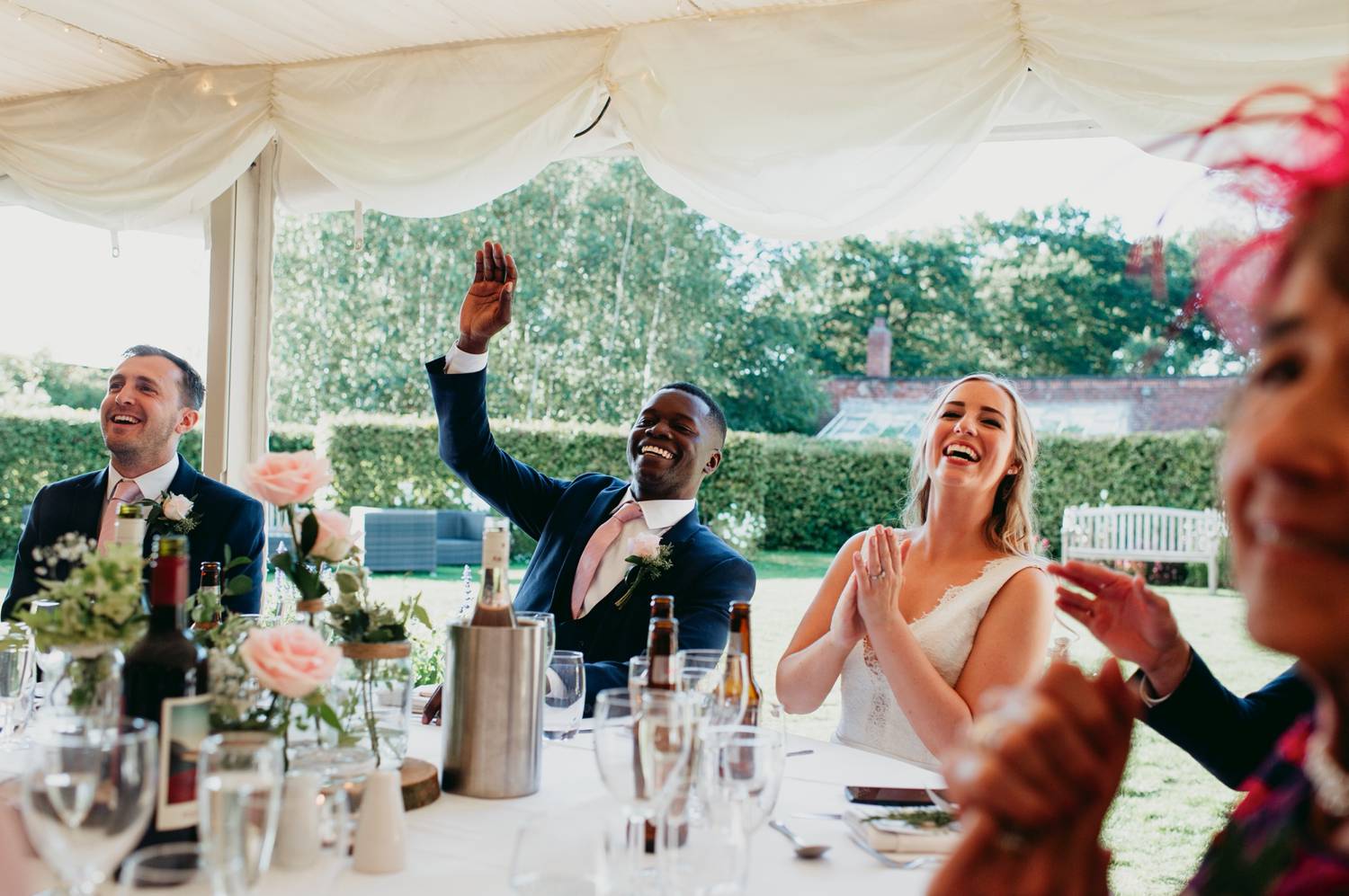 Bride and groom cheer and toast under a tent