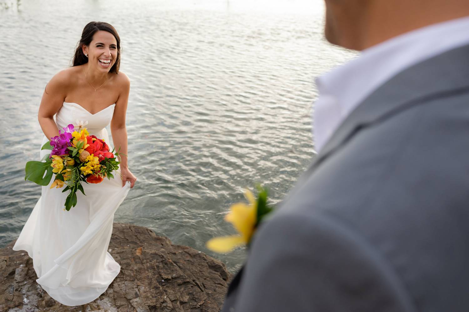 Client Experience: A photo by Kevin Heslin depicts a bride as she approaches her groom during their first look on a beach.