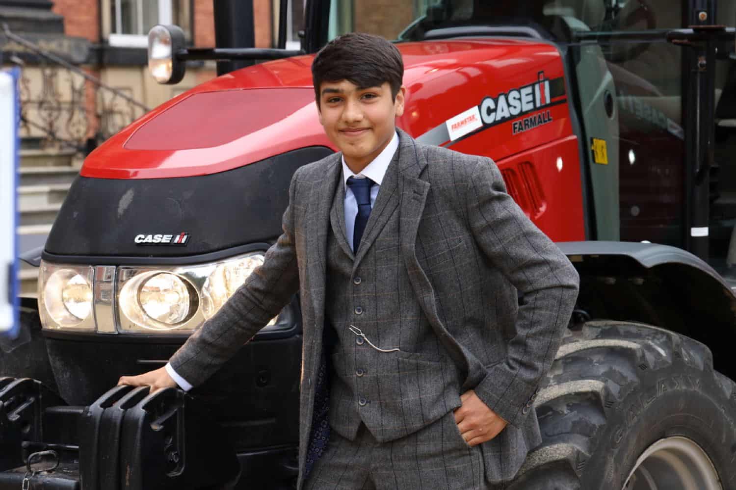 A high school senior boy poses for his prom photography