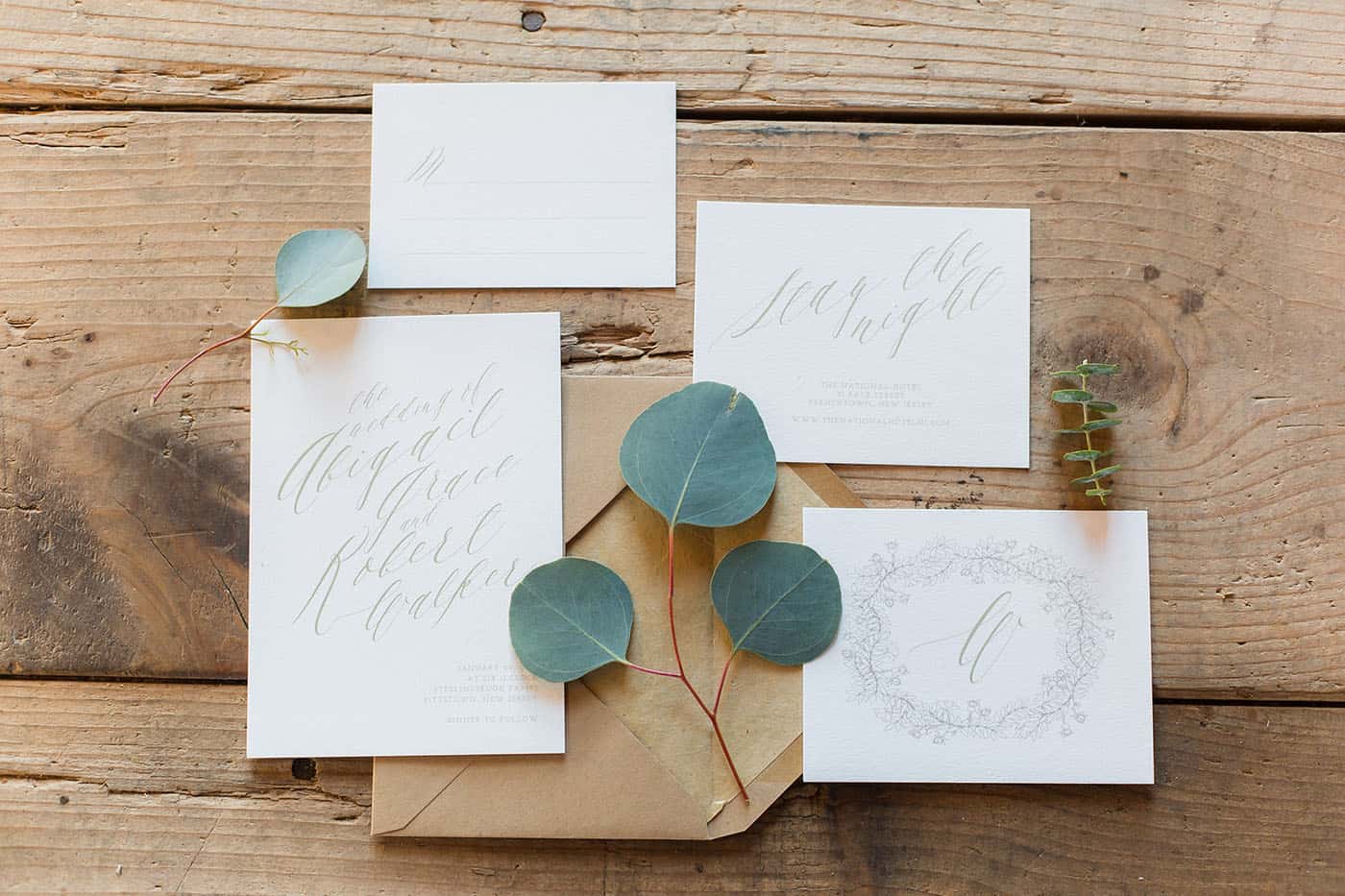 wedding invitation set on a wooden table with leaves by customer service whiz cinnamon wolfe