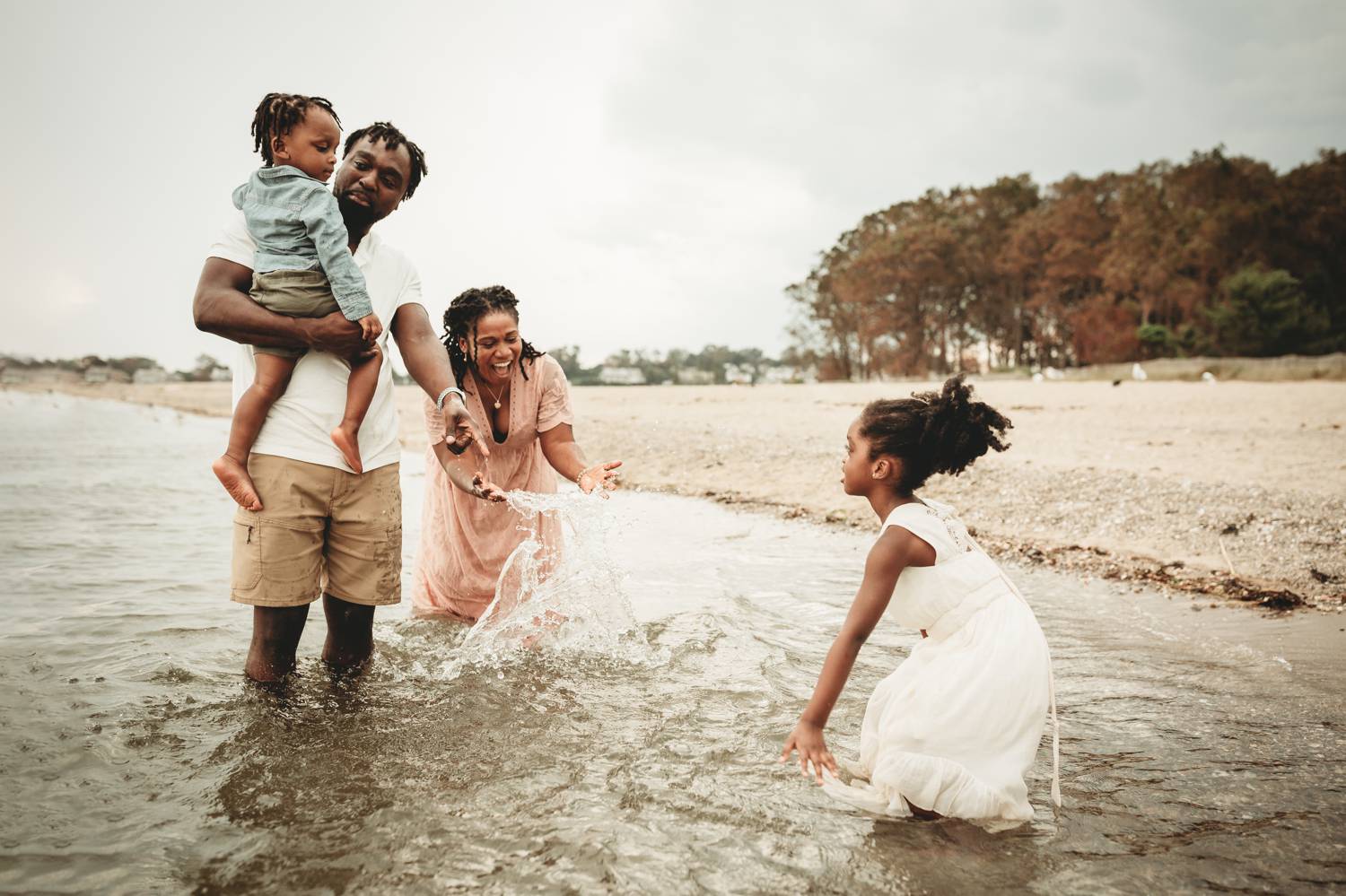 A family plays in the shallow bay waters