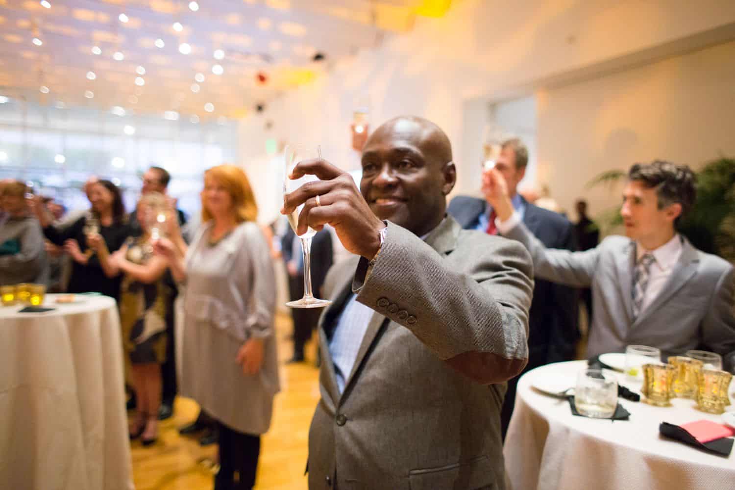 Build Your Dream Photography Business on a Budget: Man gives champagne toast at business event