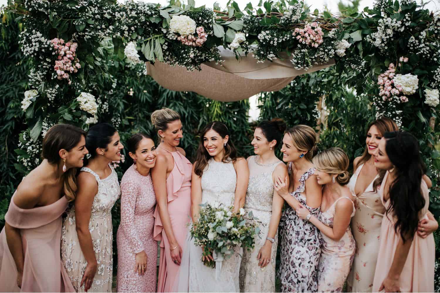 Wedding Print Packages: A bride and her bridesmaids stand under a floral chuppah.